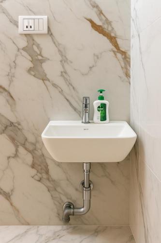 a bathroom sink with a soap bottle on it at Hotel Aasi inn in Nagpur