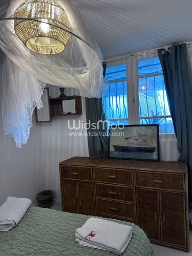 une chambre avec un lit, une commode et une fenêtre dans l'établissement La plage d'Ugo, à Mauguio