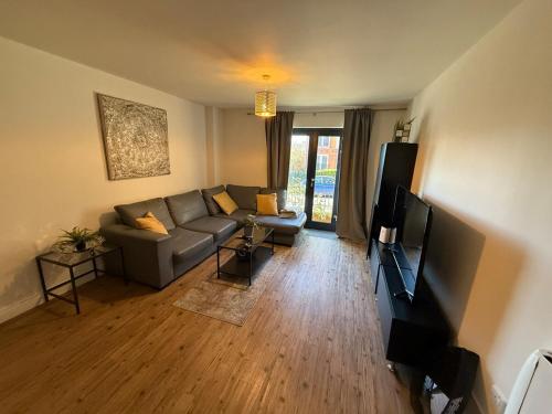 un soggiorno con divano e TV a schermo piatto di Stylish 2 Bed Flat by O2 Arena Modern Comfort in Central Birmingham a Birmingham