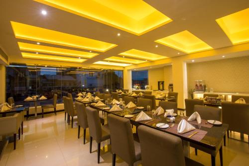 a restaurant with long tables and chairs and yellow ceilings at Best Western Elyon Colombo in Colombo
