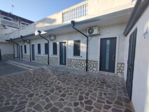 a white building with a cobblestone street in front of it at Maresila in Amica