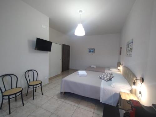 a bedroom with a bed and two chairs and a television at Maresila in Amica