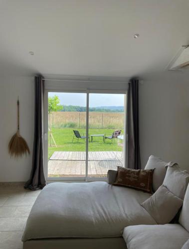 - un salon avec un canapé en face d'une fenêtre dans l'établissement Longère cosy, à Saint-Maurice-lʼExil