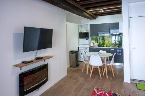 Elle comprend un salon avec une cheminée et une télévision murale. dans l'établissement Gite Boiscorde, coeur du Perche, Wifi, à Rémalard