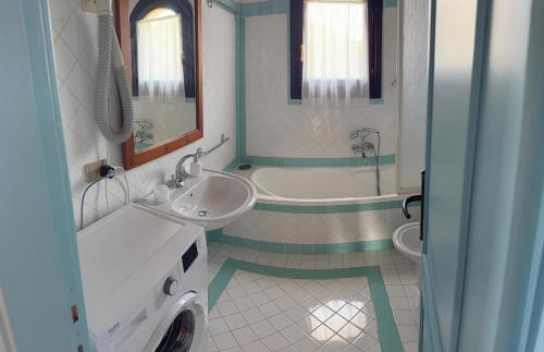 a bathroom with two sinks and a tub and a sink at Appartamento La Vela Blu in Cuile Pazzoni