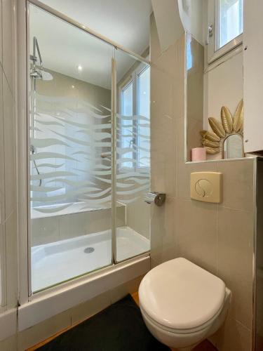 une salle de bain blanche avec douche et toilettes dans l'établissement Appartement Tour Eiffel Maison de la Radio, à Paris