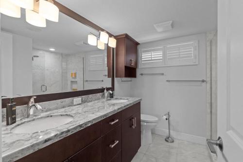 Un baño con lavabo, inodoro y espejo. en Lighthouse Point 325, en Sanibel