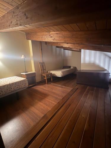 an attic room with two beds and a table at Hotel Guara Inlukā in Las Almunias
