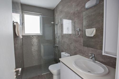 ein Badezimmer mit Waschbecken, Toilette und Dusche in der Unterkunft Villa Olive Gold, Luxury And Brand New 2Bdr Protaras Villa With Private Pool in Protaras