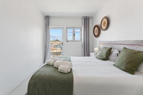 a bedroom with a large white bed with towels on it at GuestReady - Lovely home with river view in Bandeira