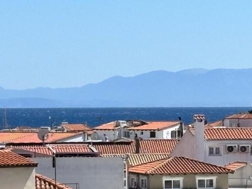 a view of roofs of buildings with mountains in the background at Vaya Zorba Studios in Skiathos Town