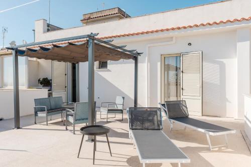 a group of chairs and tables on a patio at Bed And Breakfast Champagneria in Castelvetrano Selinunte