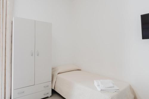 a white bedroom with a bed and a dresser at Bed And Breakfast Champagneria in Castelvetrano Selinunte