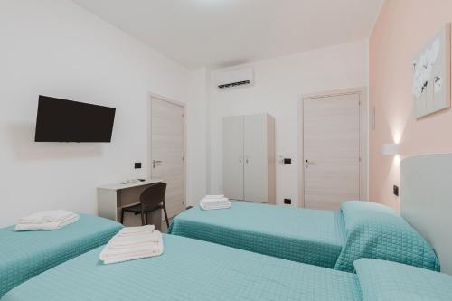 a white room with two beds and a desk at Bed And Breakfast Champagneria in Castelvetrano Selinunte
