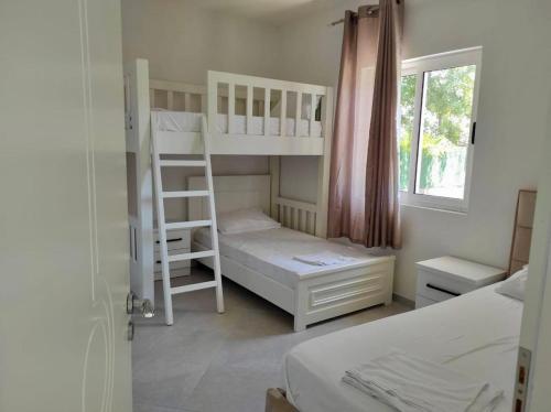 a bedroom with two bunk beds and a window at Residence Mary in Velipojë