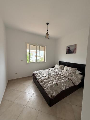 a bedroom with a large bed in a white room at Imiouadar residence tafoult appartement in Imi Ouaddar