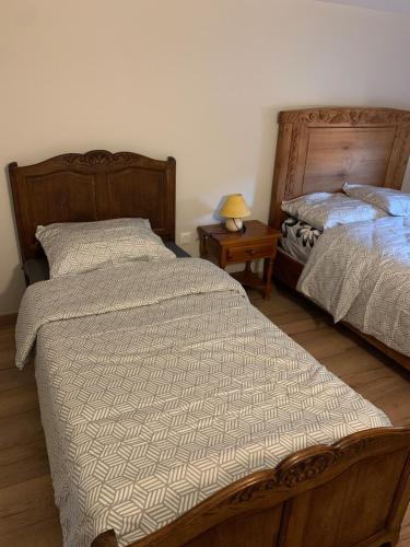 a bedroom with two beds and a table with a lamp at Appartement 3 pièces dans une maison au calme in Bonneville