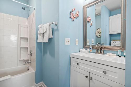 uma casa de banho com paredes azuis, um lavatório e um espelho. em Gorgeous 2 Bedroom Condo for 6! Summer Times Unit 8 em Myrtle Beach