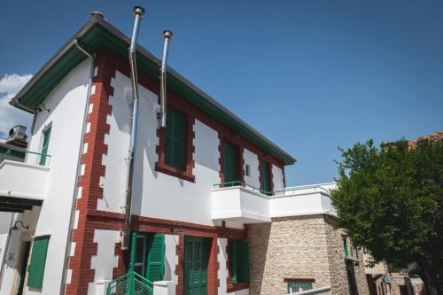 a building with green shuttered windows and a tree at Elite luxury Suites in Omodos