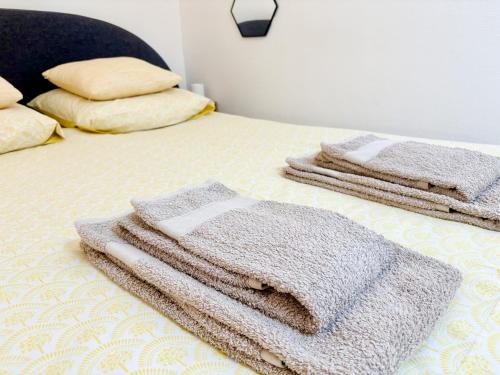 une pile de serviettes assises sur un lit dans l'établissement La Suite aquitaine, à Bordeaux