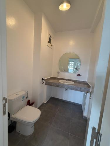 a bathroom with a toilet and a sink and a mirror at Imiouadar residence tafoult appartement in Imi Ouaddar