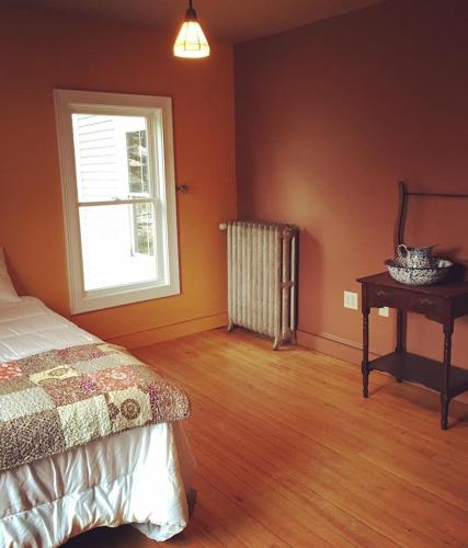 a bedroom with a bed and a window and a table at Spillover Motel and Inn in Stratton