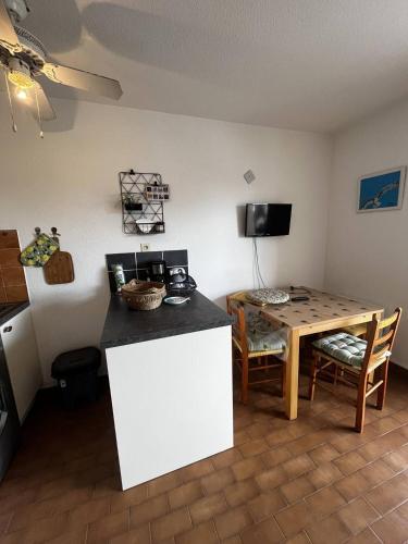 une cuisine et une salle à manger avec une table et une table et des chaises dans l'établissement Studio Cabine pour 4 avec Ascenseur – Vue Marina, Plage à 2 Pas, à Canet