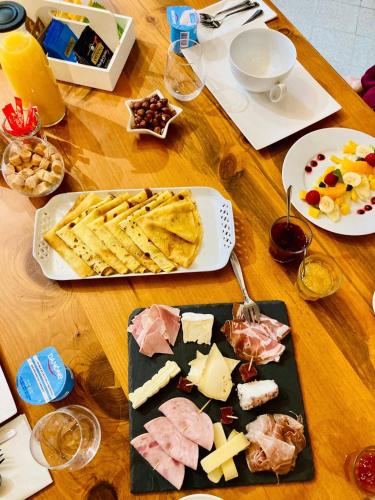 Una mesa de madera con un plato de queso y galletas. en Au Clos de Charny, en Charny