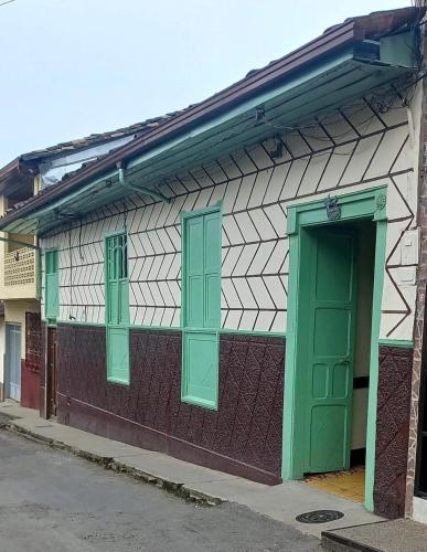 a building with green windows and a green door at Casa colonial con encanto en Sonsón in Sonsón
