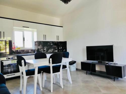 a living room with a table and chairs and a tv at Residence Mary in Velipojë