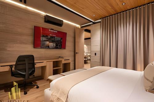 a bedroom with a bed and a desk with a computer at Casa Biflora - Natural luxury in top location in El Poblado