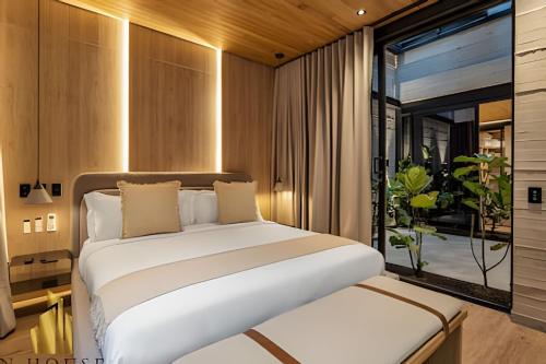 a bedroom with a large white bed and a window at Casa Biflora - Natural luxury in top location in El Poblado