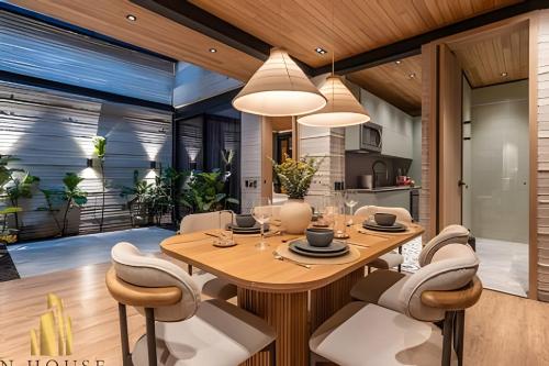 a dining room with a wooden table and chairs at Casa Biflora - Natural luxury in top location in El Poblado