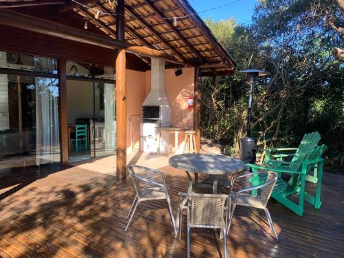 a patio with a table and chairs and a stove at Pousada Watu Kerere in Praia do Rosa