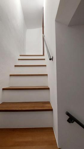 a staircase in a house with white walls and wooden floors at Selice 9 B&B in Casaletto Spartano