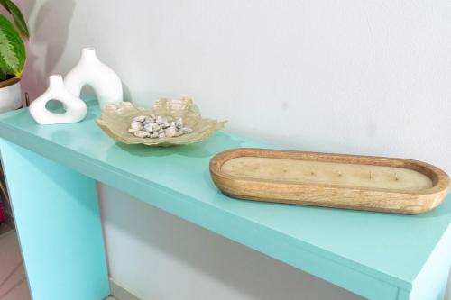 a blue shelf with a wooden tray and vases on it at Hotel Aguamarina in Santa Marta