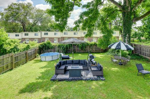 a backyard with a couch and an umbrella and chairs at Outdoor Pool and Hot Tub Retreat - 6 Mi to Dtwn! in Baltimore