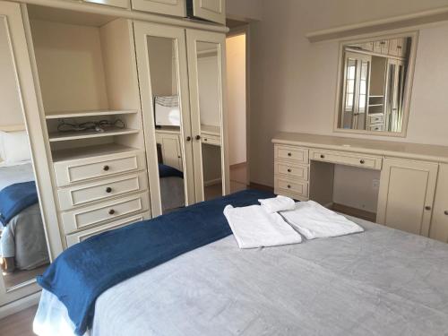 a bedroom with a bed with two towels on it at Apartamento na Avenida Borges a 100 m da Rua Coberta in Gramado