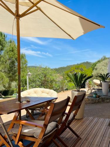 a table and chairs with an umbrella on a deck at NOUS in Agel