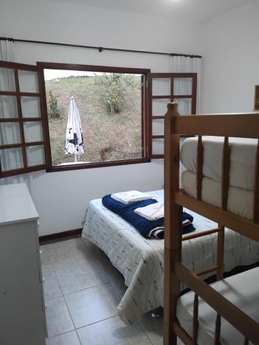 a bedroom with a bunk bed and a window at Casa de Campo em Teresópolis in Teresópolis