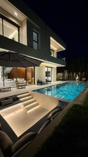 a large house with a swimming pool at night at Villa Talya in Marrakech