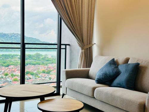 a living room with a couch and a large window at Explore Penang Stay Style w Sky pool Sea airport 9pax in Bayan Lepas