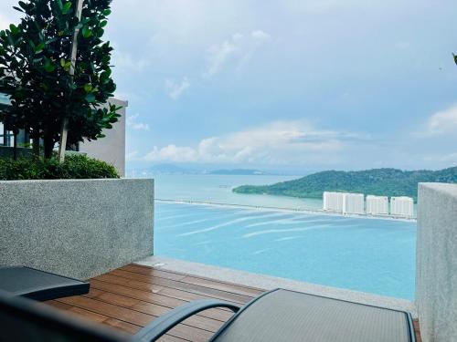 a swimming pool with a view of the ocean at Explore Penang Stay Style w Sky pool Sea airport 9pax in Bayan Lepas