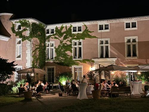 a group of people sitting outside of a building at night at Chateau d Artigues en Provence in Artigues