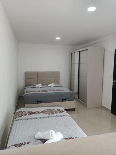 Dos camas en una habitación con paredes blancas. en Vila Eden, en Bar