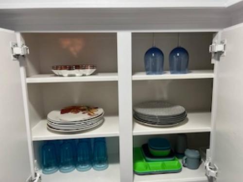 a cupboard filled with plates and blue vases at Houston Getaway | 6BR |Pool| Wi-Fi| Sleep 16|Pool in Houston