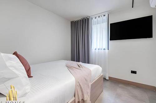 a bedroom with a bed and a flat screen tv at Casa Solei 12-7 - Bright & Chic Apt in Manila / AC in El Poblado
