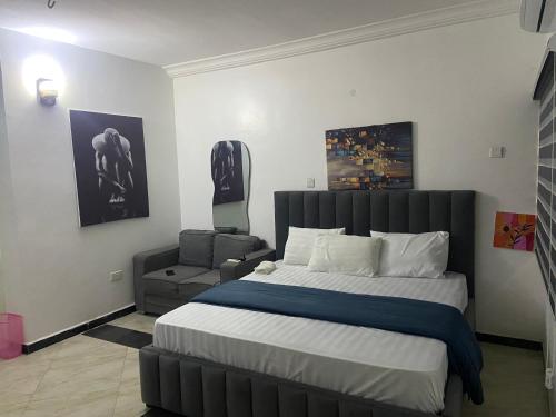 a bedroom with a large bed and a chair at Zimmy Apartment in Ankuru
