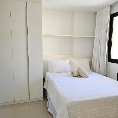 a bedroom with a bed with white sheets and a window at Flat in Copacabana in Rio de Janeiro