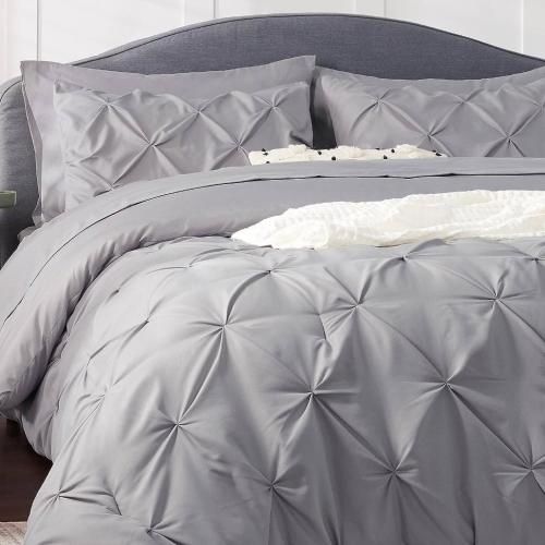 a bed with a gray comforter and pillows at Houston Getaway | 6BR |Pool| Wi-Fi| Sleep 16|Pool in Houston
